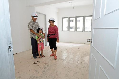 Majestic Heights unit owner Cheah Hooi Hin and wife Lilly Teh, both 65, and their granddaughter inspecting their soon-to-be-ready home in Paya Terubong.