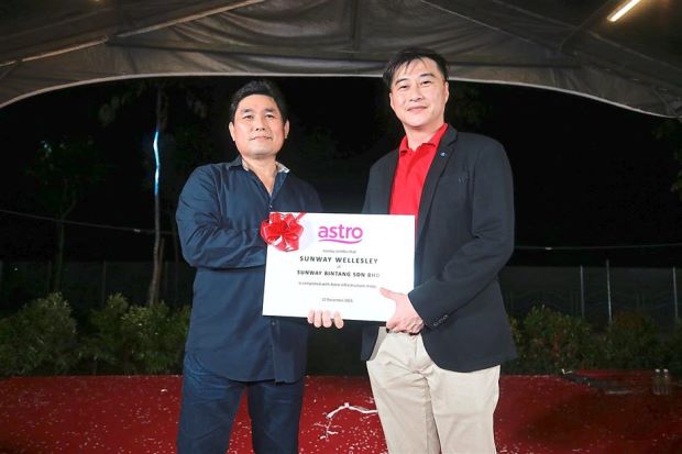 Tan (right) receiving a certification from Astro northern region vice-president Woo Tuck Fatt to signify their collaboration in implementing the ‘Astro Infrastructure Ready Home’ effort at Sunway Wellesley, Bukit Mertajam.