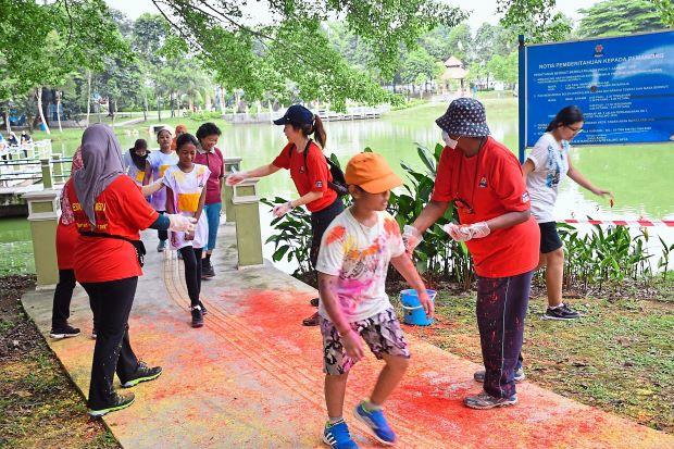 Participants in the Colour Walk being smeared with food dye powder at one of the stations.