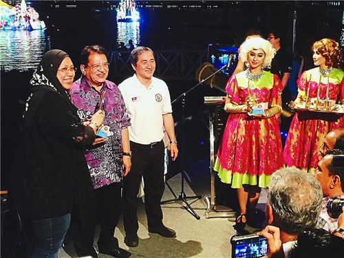 Noorul Ashikin (left) receiving the trophy from Tengku Adnan (second from left).