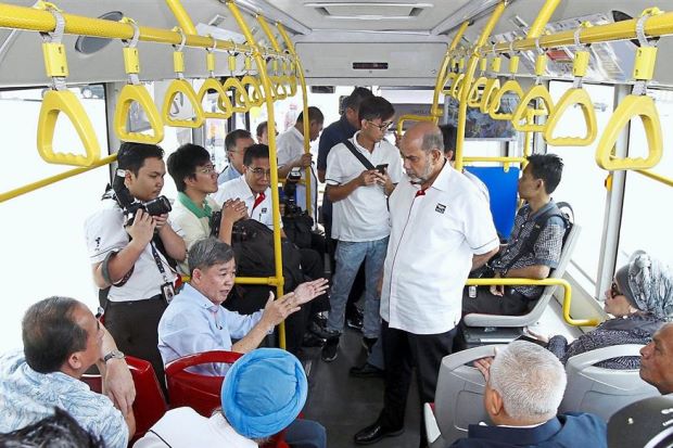 Perak Transit Managing Director Datuk Seri Cheong Kong Fitt (seated second from left) speaking with Syed Hamid (standing right) on board the MyBas.