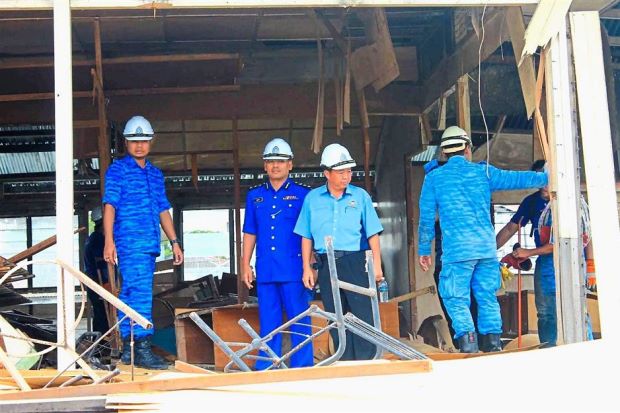 Getting to work: Yeo (centre) inspecting demolitions at the illegal settlements at Kg Sembulan in Kota Kinabalu.
