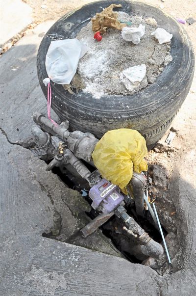 A maze of pipes blocking access to a drain hole opening, making it impossible for the cleaning contractors to do their jobs.