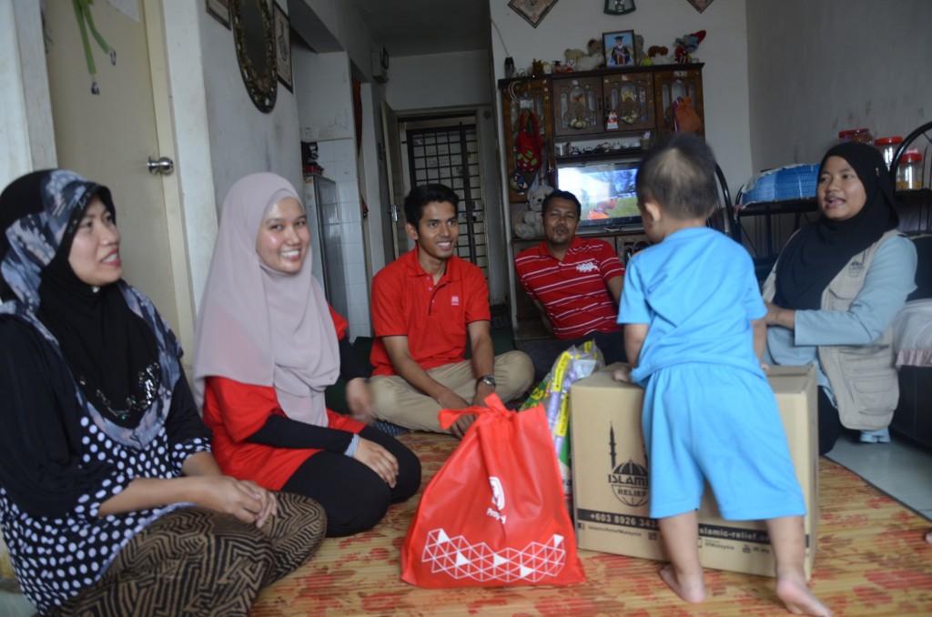 Volunteers spending time to chat with a family chosen as one of the Sime Darby Property Community Development Programme recipients. 