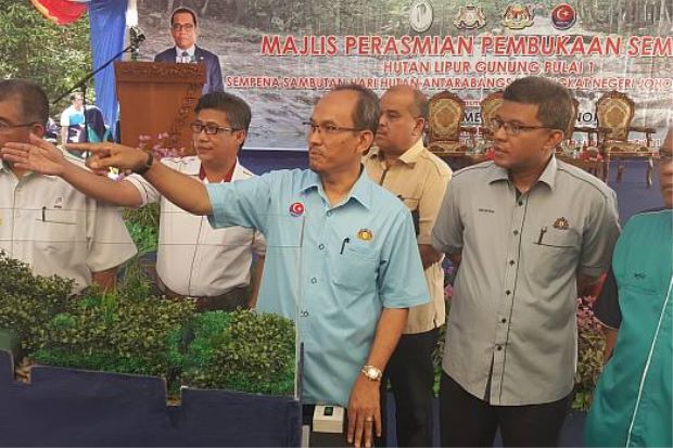 Jais (third from left) being briefed on the newly installed early warning system at the Gunung Pulai Forest Reserve on Tuesday.