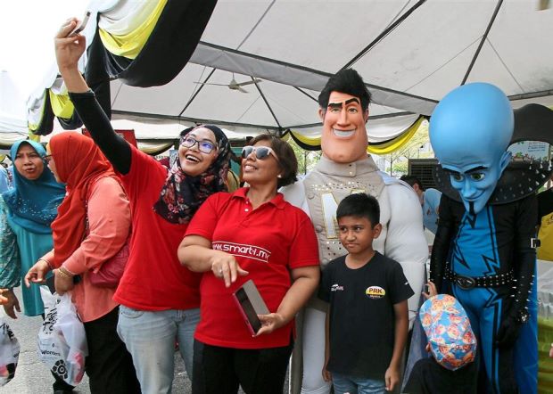 Visitors taking pictures with Movie Animation Park Studio characters during the launch of the campaign to Promote Visit Perak Year.