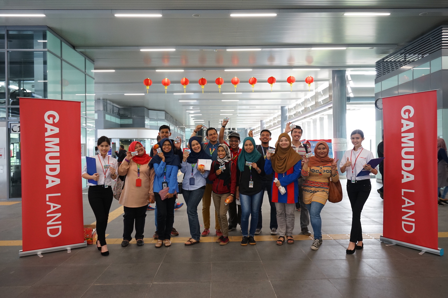 Happy_Commuters_at_Sungai_Buloh_MRT_Station_receiving_their_TnG_Cards_and_mandarin_oranges_from_Gamuda_Land