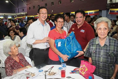 Tengku Adnan (second from right) presenting a goodie bag to one of the guests at the event. Looking on is Gerakan vice-president Datuk Dominic Lau Hoe Chai (in white shirt).