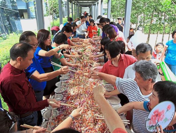 Guests at the Red Rooster Celebration tossing a 2m-long prosperity yee sang.
