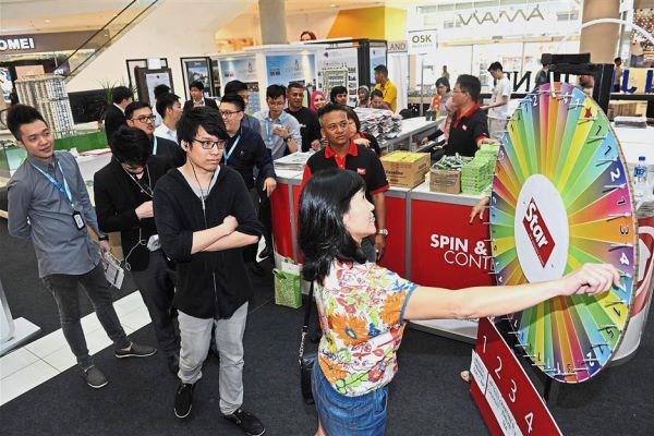 Visitors lining up to take part in the Spin & Win Contest and (bottom pic) being briefed on a project at last year’s property fair at Aman Central Mall, Alor Setar.