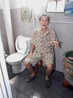 Koay showing the toilet bowl as well as floor and wall tiles that were newly installed at his bathroom.