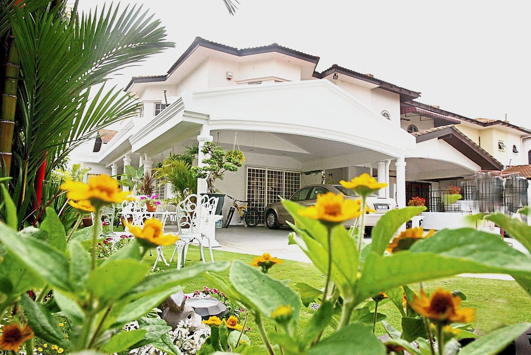 All available land in Chin's corner house has been cultivated and filled with flowers and shrubs