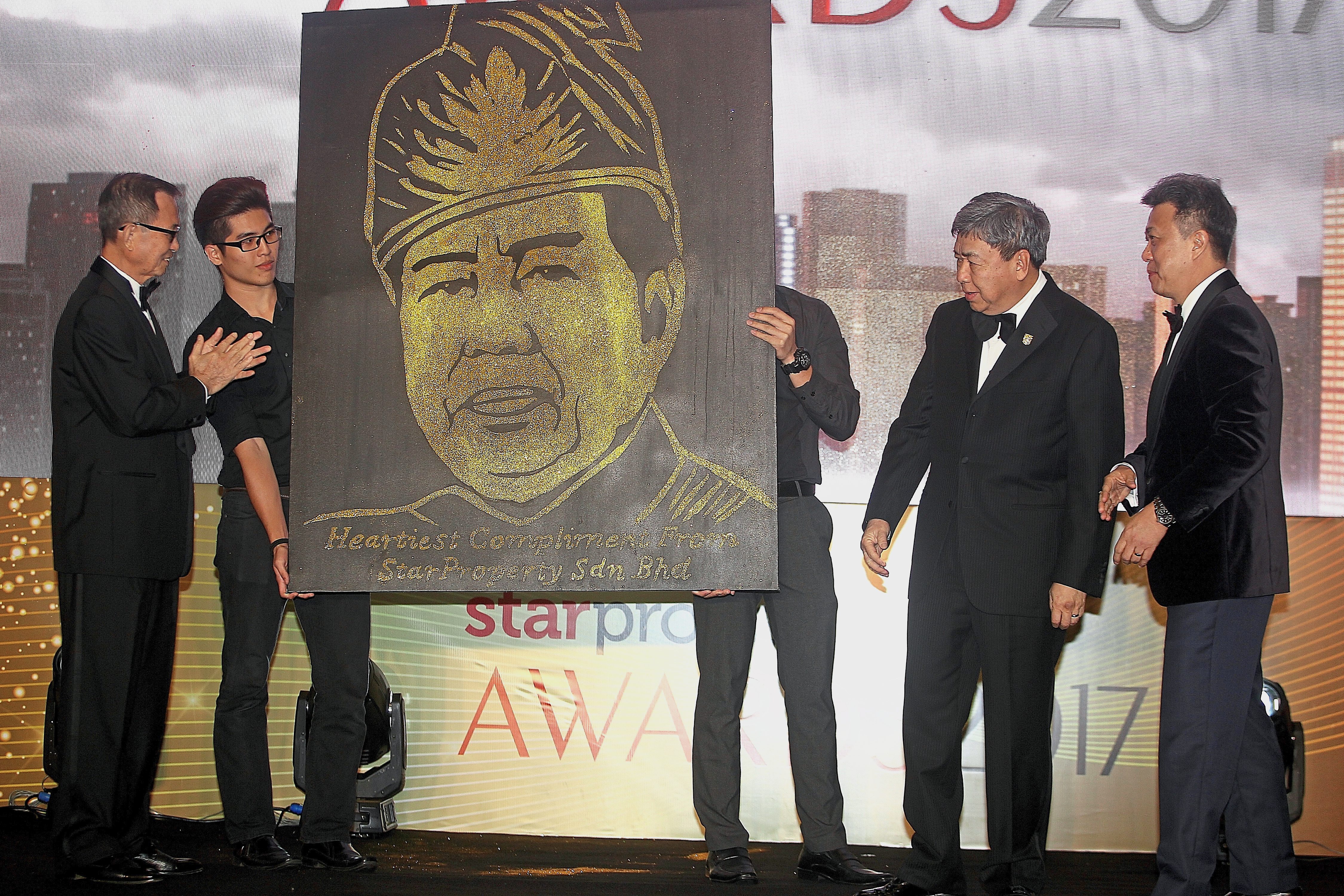 Sultan Sharafuddin Idris Shah of Selangor, accompanied by Star Media Group Bhd chairman Datuk Fu Ah Kiow (left) and group MD and CEO Datuk Seri Wong Chun Wai (right), being presented with a portrait of himself at the Star Property.my Awards Night 2017.