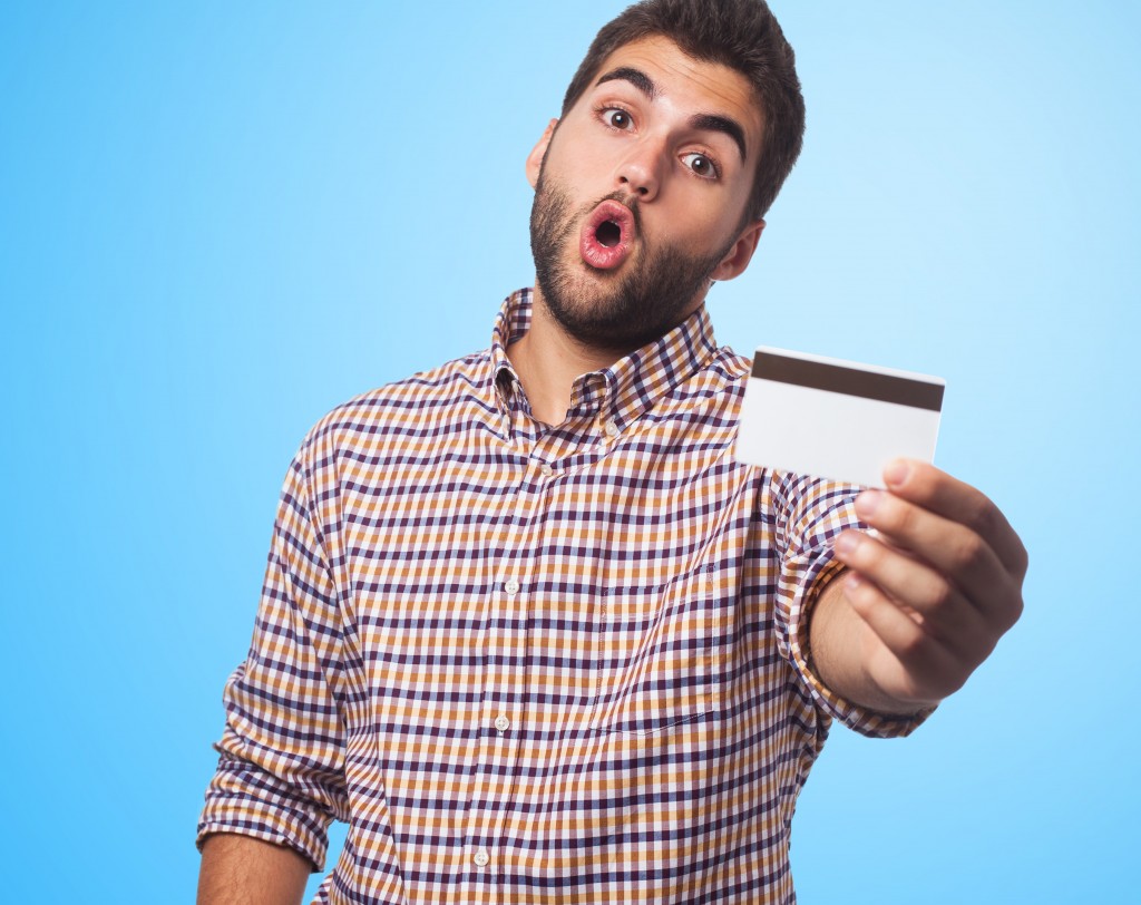portrait of a young man holding a credit card