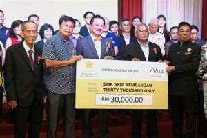Eng (front row, centre) presenting the mock cheque of RM30,000 for the school’s new auditorium project to Tay (front row, right). With them are (from left) Loo, Liew and Teo.