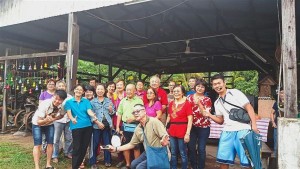 Saw (right, in red floral blouse) and tour guide CJ Teo (right) with a group of Singaporean tourists at Happy Farm at Kampung Baru Bekok in Johor.