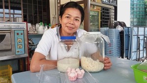 Tee showing the traditional way to make fatt koh, a type of steamed cake, at her house in the village.