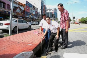 Liew showing the 0.9m-wide and 0.6m-deep pothole at the traffic light junction in Jalan Cheras Indah.