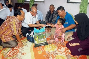 Bentan, accompanied by his wife Rohani and daughter Nurul Izzah, receiving foodstuff and cash aid from Redza (in white). Also present is Muhammad Farid (left). — Photos: CHARLES MARIASOOSAY/ The Star