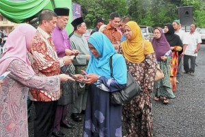 Azmin (second from left) presenting monetary aid to villagers in Hulu Langat who were affected by the floods on June 17.