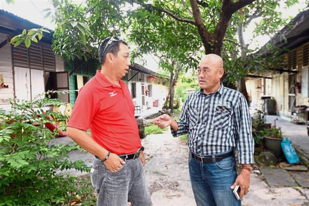 Song Ming (left) and Lian Chong discussing the issue of flash floods in the area as a result of development.
