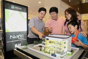 Customer service representative Jones Chin (in grey) explaining the NafiriVal d’Or project to visitors at the booth of GUH Realty Sdn Bhd in Gurney Plaza. 