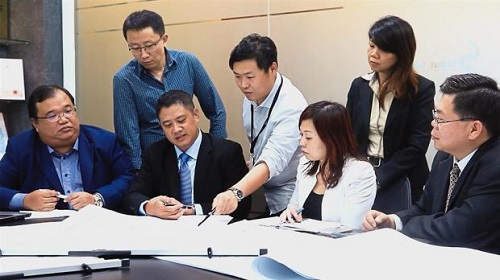 Working together: (seated from left) Tay, Yang and Low (right) having a discussion with the team on how to take the company forward.