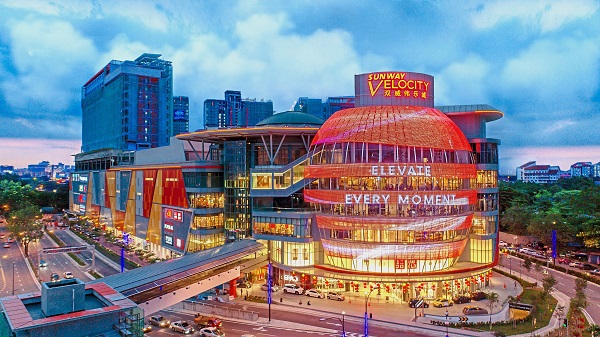 Night view of the Sunway Velocity Mall facade.