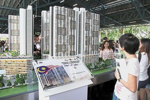 Visitors checking out a scale model of Residensi Desa Satumas.