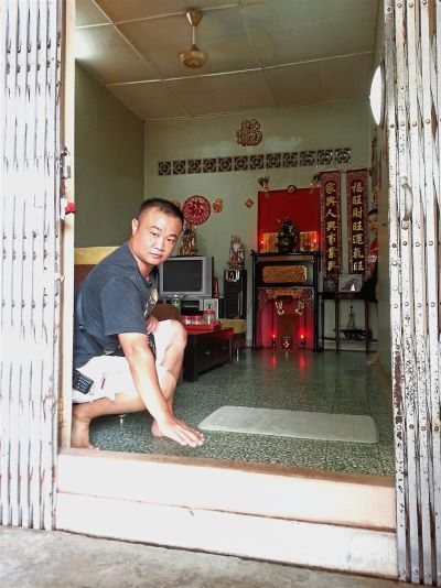 A resident, Yeo Tong Keong showing the height he has to raise the front entrance to keep flood waters out.