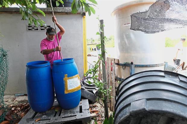 Ahmad Zulkifli Hashim, 55, stirring the compost made up of kitchen scraps and brown sugar that is used both as a fertiliser as well as sewage tank cleaner.