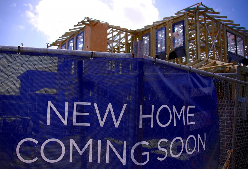 FILE PHOTO: A house under construction can be seen behind an advertising banner at a housing development located in the western Sydney suburb of Oran Park