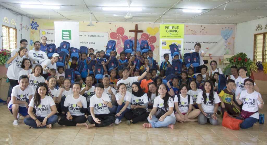 The volunteers of M101 and PeopleGiving together with the children of Kampung Bertang after receiving their gifts.