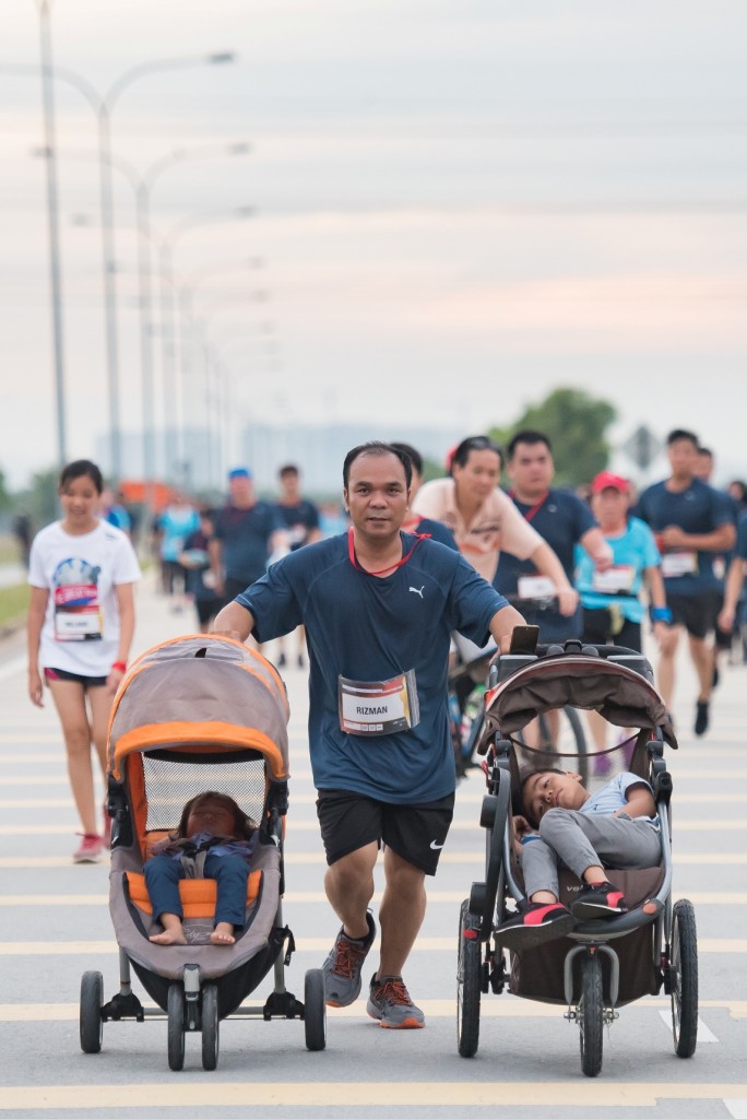 A father of two participating in the run while pushing his children in their strollers. Super dad in action!