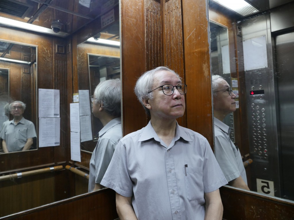 Landlord Ng Goon-lau, 66, poses inside a lift of a building where two suicides have taken place in his property, in Hong Kong.