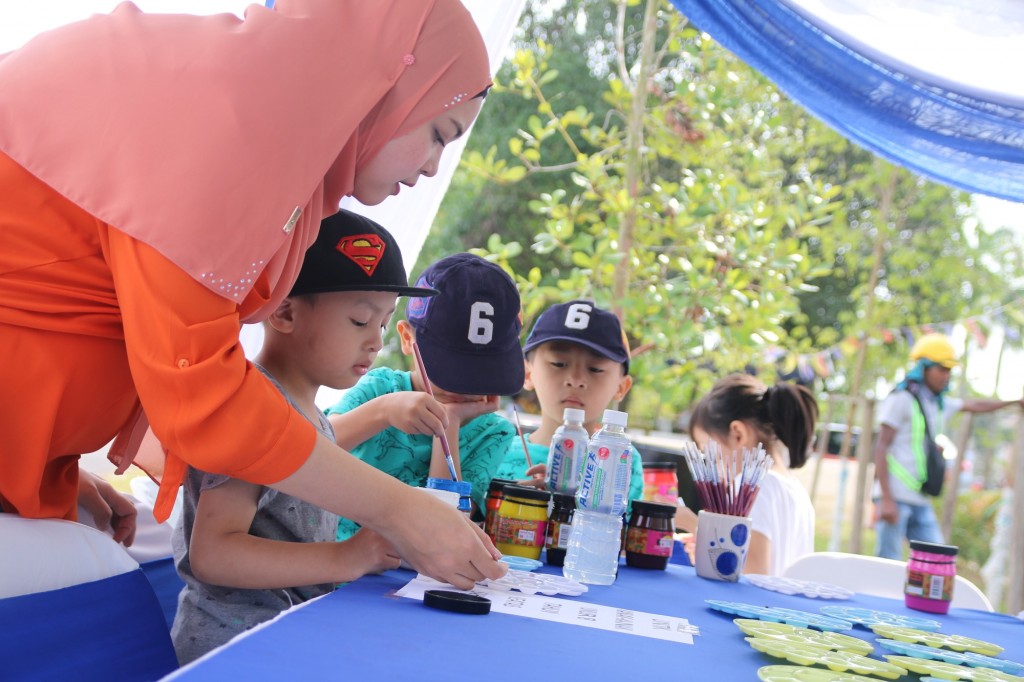 Children from Mahligai and Nusa Damai area painting the mural during the event.
