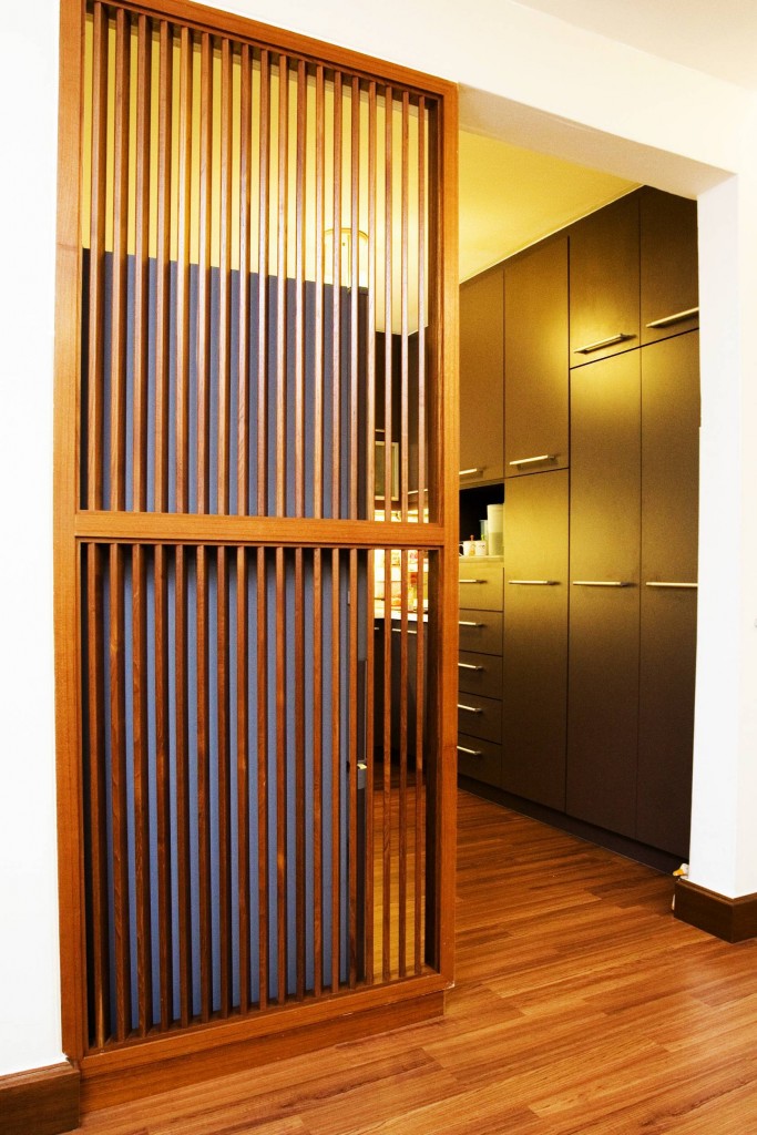 The portal leading to the kitchen is partially shielded by a wooden screen to hide the refrigerator. Note that the very latest in shelving systems from Maxima have been installed to give a more modern look to the space.