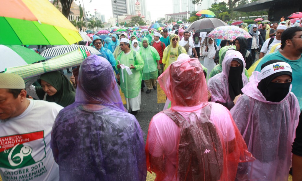 Protesters wearing raincoats during a gathering in Kuala Lumpur to protest the proposed ratification of the ICERD.