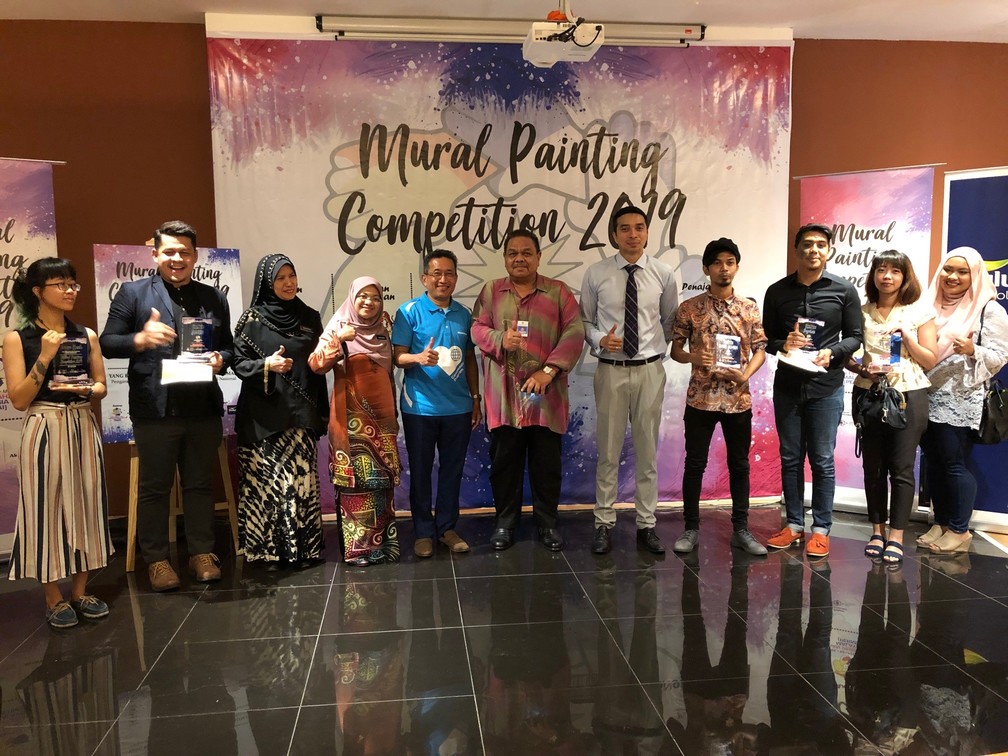 Officials from PERMAI, PERPADUAN, DBKL and AkzoNobel poses with the winners from the Creative Mural Project after the awards ceremony held at Museum Telekom. From left to right: Ellie Yong Sze Chin (5th Place), Mohd Amin Bin Hadarih (Winner), Pn. Sharifah Junidah Bt. Syed Omar, Deputy Director of Project Implementation & Building Maintenance (DBKL), Pn. Norzaini Bt. Nordin Deputy Director of Project Implementation & Building Maintenance (DBKL), Mr Indra Laban General Manager, Decorative Paints Malaysia, Tuan Mohd Khalil bin Ahmad, Director of Social Unity & National Integration Division, En. Afiq Amani Annuar, Head of Operations of Yayasan Persahabatan Malaysia (PERMAI), Dhiyaul Mohamad Ashraf bin Dawari (2nd Place), Wan Iqmahl Hisham (4th Place), Norasyikin Abdullah and Nurul Afiqah (3rd Place).