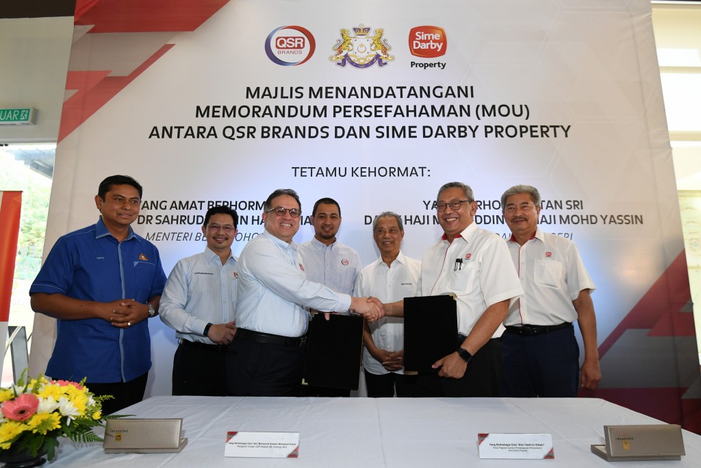 Sime Darby Property chief operating officer Township Development Datuk Wan Hashimi Albakri and QSR Brands managing director Datuk Seri Mohamed Azahari exchanging the MoU documents. 