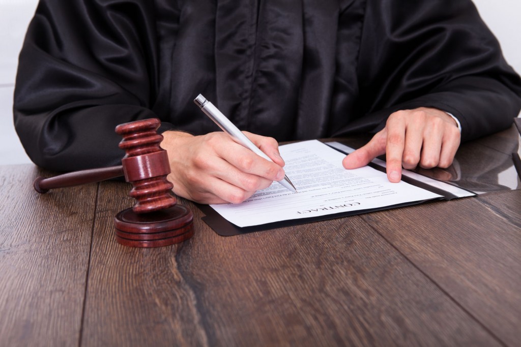 23934666 - close-up of a judge hitting mallet at desk