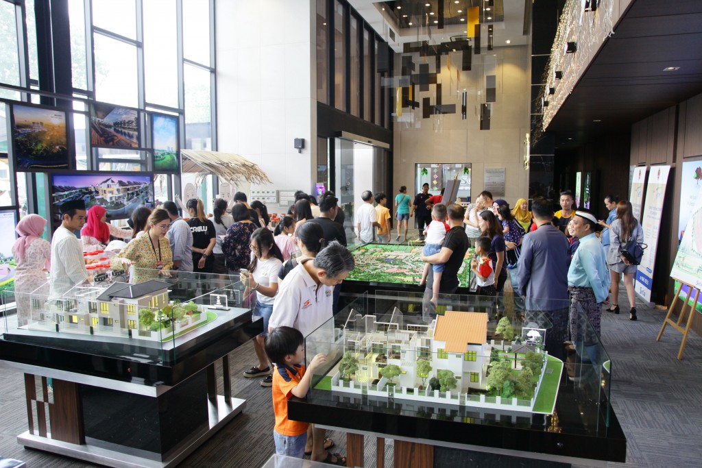 Potential buyers checking out the scale model houses at the Taman Pelangi Indah sales gallery.