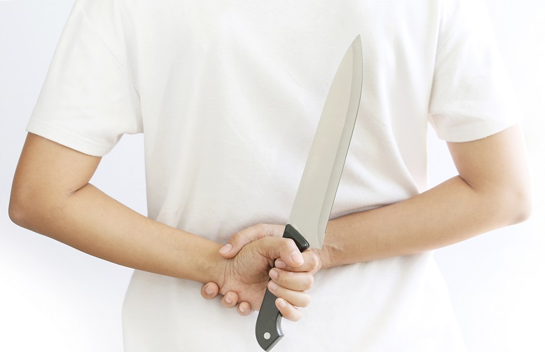 woman hiding kitchen knife.