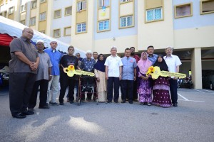 Ahmad Zakiyuddin (seventh right) and Mohd Salem (sixth right) taking a group photo with the villagers of Kampung Mutiara after handing over the mock keys of Selasih Court to them