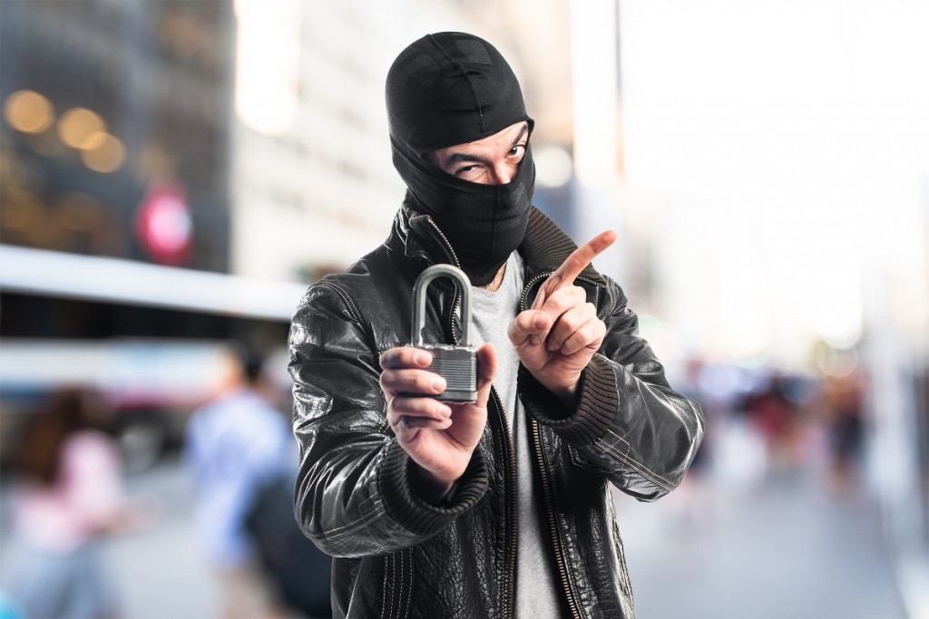 Robber holding vintage padlock on unfocused background