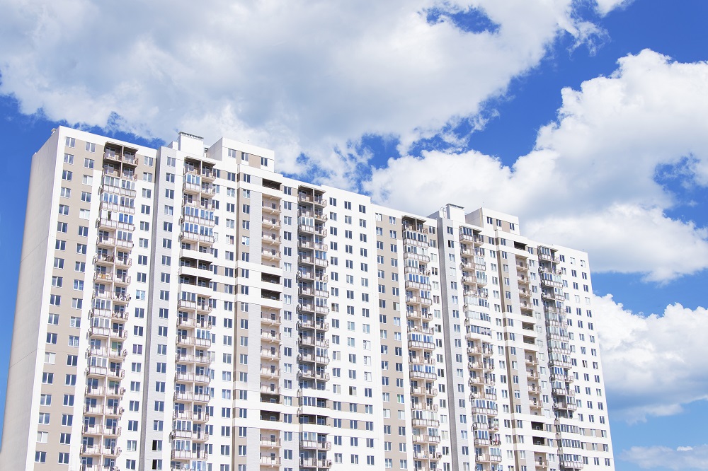 New modern multi-storey residential complex. Blue sky with large white clouds