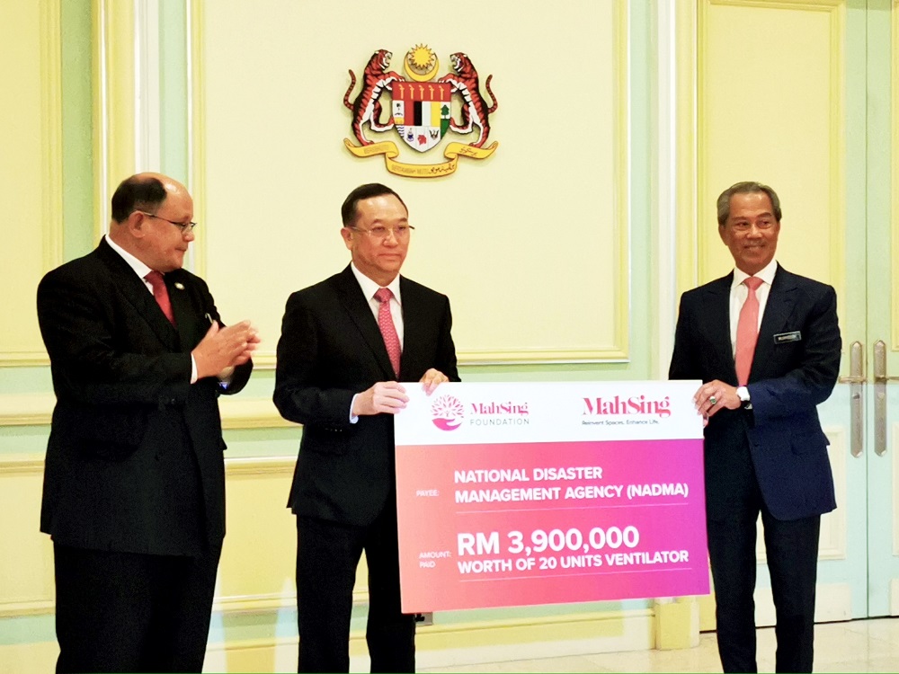 Leong presenting the donation pledge to Prime Minister Tan Sri Muhyiddin Yasin.