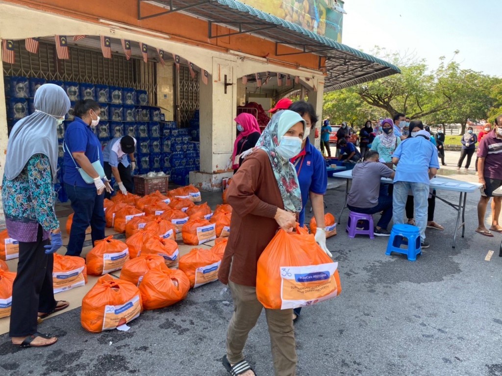 Sime Darby Property business unit employees distributing essential items to nearly 100 families living at the Seri Mutiara Flats in Putra Heights during the MCO.