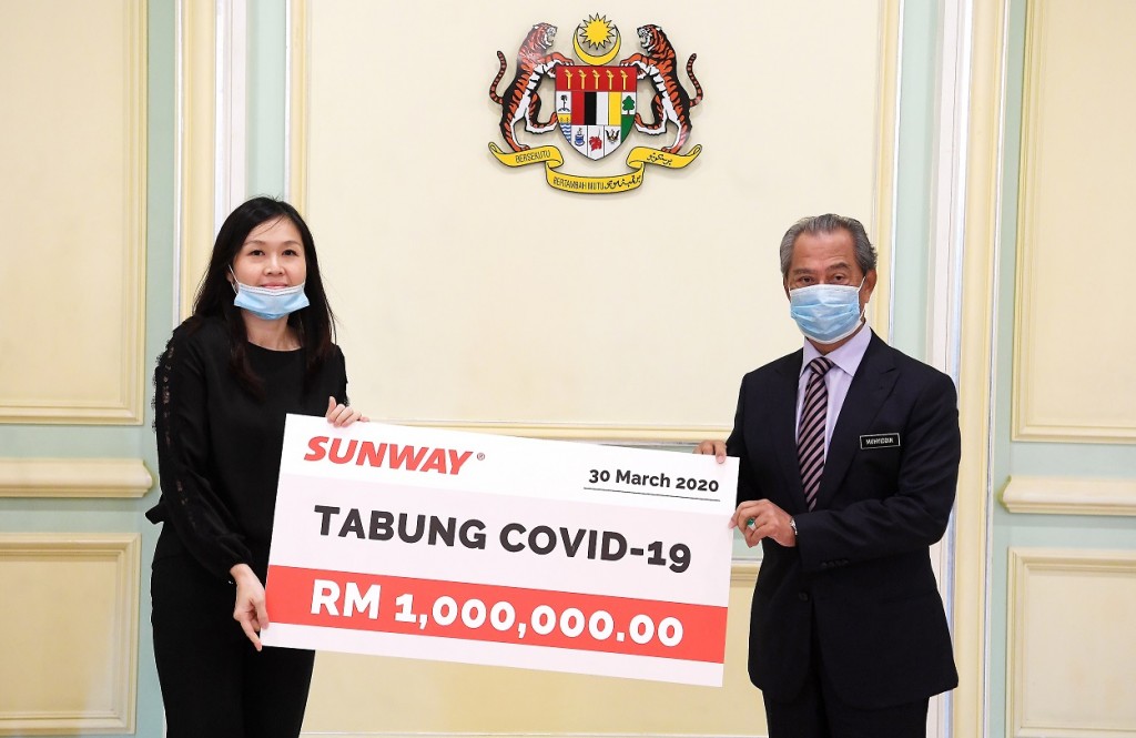 The Prime Minister receiving a RM1mil mock cheque for Covid-19 Fund from Sunway executive director and property division managing director Sarena Cheah.