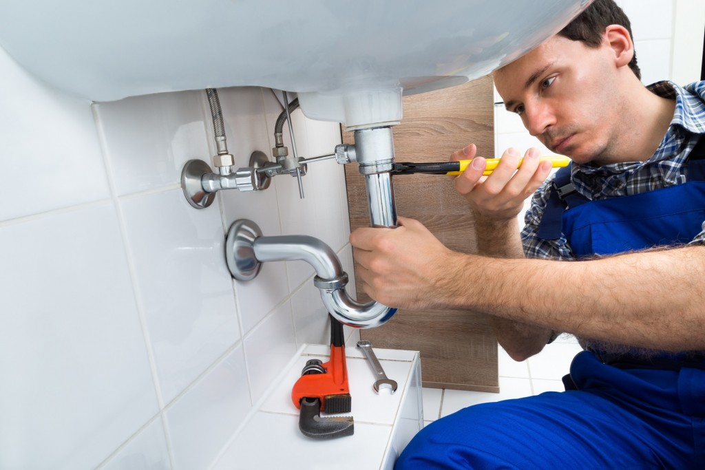 Plumber Fixing Sink In Bathroom